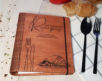 May include: A wooden recipe book with a black elastic band closure. The cover is engraved with the text "My Favorite Recipes" and a graphic of a roasted turkey. The text below the title reads "The Best Food Recipes That are Delicious, Healthy, Great for Energy and Easy to Make."