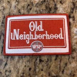 May include: Orange and white embroidered patch with the text "Old Neighborhood" and a logo with the letters "WSP" inside a circle.