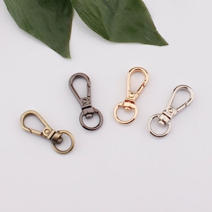 Puede incluir: Cuatro cierres giratorios de metal en diferentes acabados: latón antiguo, oro, plata y negro.