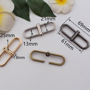 May include: Three metal D-ring clasps in gold, silver, and bronze. The gold clasp measures 25 mm by 13 mm, the silver clasp measures 69 mm by 61 mm, and the bronze clasp measures 21 mm by 8 mm.