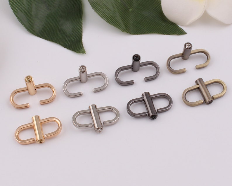 May include: Eight metal clasps with a decorative crystal in the center. The clasps are in various finishes, including gold, silver, and black.