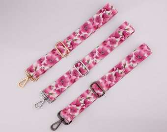 Pode incluir: Três tiras de tecido com padrão floral rosa com fechos de metal dourado, prateado e bronze. As tiras têm aproximadamente 2,5 cm de largura.