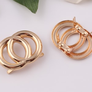 Pu&ograve; includere: Chiusura a doppia anello in metallo dorato con chiusura a molla. La chiusura &egrave; progettata per essere utilizzata per fissare cinturini o altri accessori.