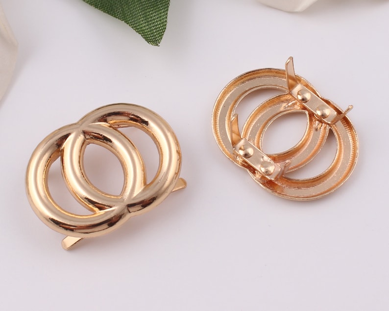 Pu&ograve; includere: Chiusura a doppia anello in metallo dorato con chiusura a molla. La chiusura &egrave; progettata per essere utilizzata per fissare cinturini o altri accessori.