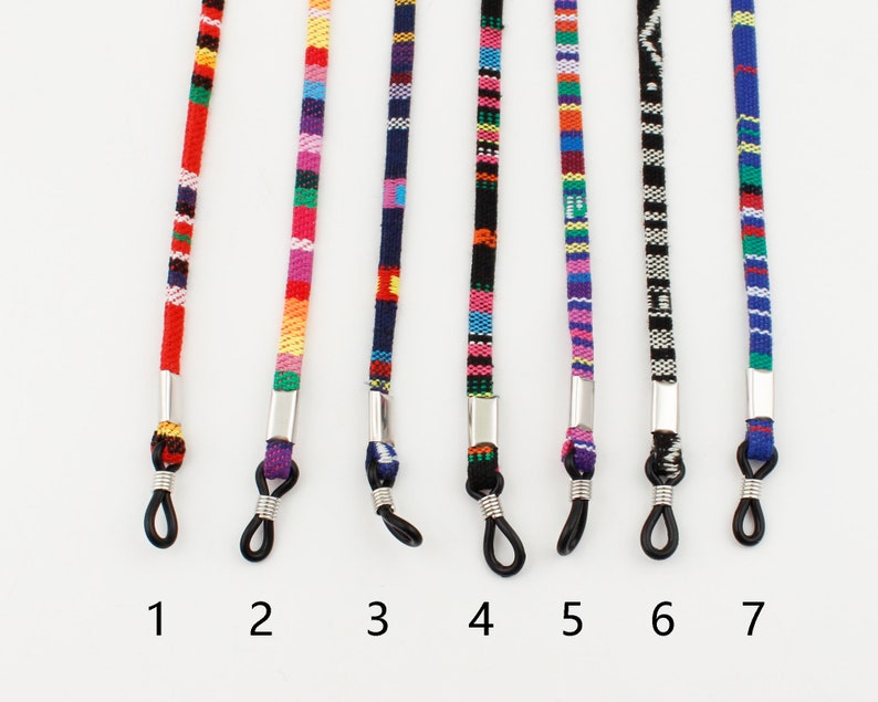 Puede incluir: Siete cadenas de gafas coloridas con cierres de metal plateado. Las cadenas est&aacute;n hechas de hilo tejido y presentan diferentes patrones y colores, incluyendo rojo, azul, verde, amarillo y morado.