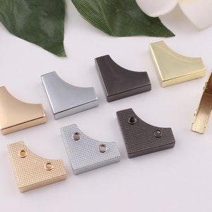May include: Assortment of corner protectors in various finishes, including gold, silver, and black. Some have a textured surface. These metal corner protectors are ideal for protecting furniture and other items from damage.