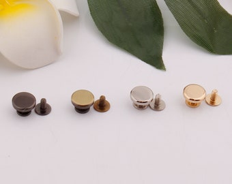 May include: Four sets of metal rivets with screws. The rivets are in black, gold, silver, and brass.