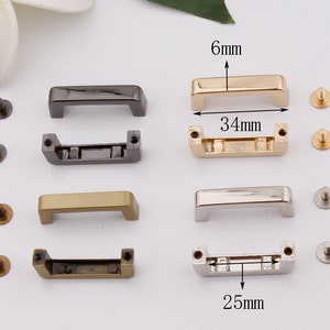 May include: Four sets of metal bag handles with matching screws. Each handle is a rectangular shape with rounded corners and a 6 mm height. The handles are available in gold, silver, black, and antique brass finishes. The handles measure 34 mm in length and 25 mm in width.