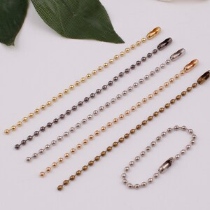May include: Six different colored ball chain keychains with a lobster clasp. The chains are gold, silver, bronze, black, and two shades of gray.