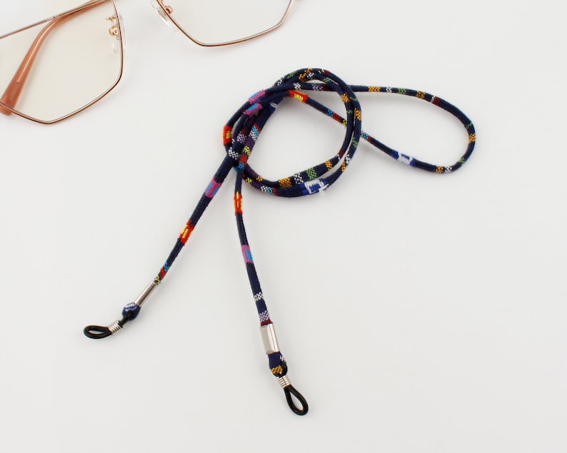 Puede incluir: Una cadena para gafas de color azul y con estampado multicolor con extremos de metal plateado. La cadena est&aacute; hecha de tejido tejido y est&aacute; dise&ntilde;ada para sujetar las gafas alrededor del cuello.