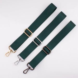 May include: Three green adjustable straps with different colored metal clasps. The straps are made of a woven fabric and have a smooth texture.