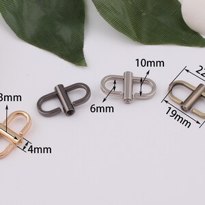May include: Three metal D-ring clasps in different finishes: gold, silver, and black. The gold clasp measures 13mm wide and 4mm thick. The silver clasp measures 10mm wide and 6mm thick. The black clasp measures 19mm wide and 22mm long.