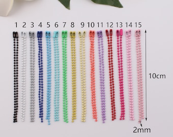 May include: Fifteen different coloured metal chains, each 10 cm long and 2 mm wide. The chains are arranged in a row, numbered 1 through 15.