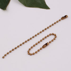 May include: A gold-toned ball chain with two swivel clasps. The chain is approximately 18 inches long.