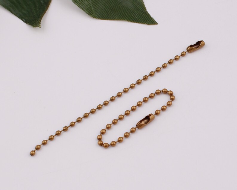 May include: A gold-toned ball chain with two swivel clasps. The chain is approximately 18 inches long.