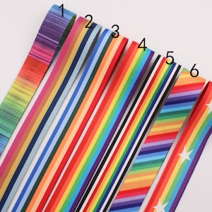 May include: Seven different rainbow striped ribbon trims with various patterns, including a white star pattern. The ribbons are arranged in a row from left to right, numbered 1 through 7.