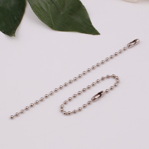 May include: A silver ball chain with a silver clasp. The chain is about 18 inches long.