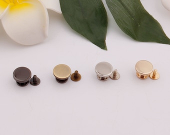 May include: Four sets of round metal snaps with screws. The snaps are in four different finishes: bronze, gold, silver, and black.
