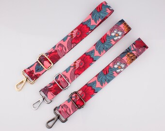 Pode incluir: Três correias ajustáveis com padrão floral rosa com ferragens metálicas douradas, prateadas e pretas. As correias são de tecido e têm um padrão floral com flores vermelhas, laranja e azuis.