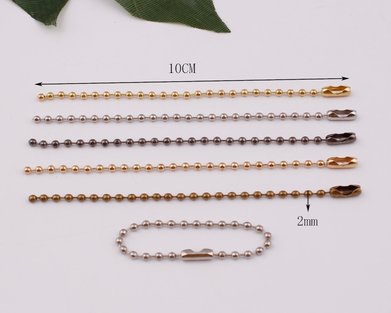 May include: Five ball chains in different colors, gold, silver, black, bronze, and silver. Each chain is 10 cm long and has a 2 mm diameter. The chains are made of metal and have a clasp at the end.