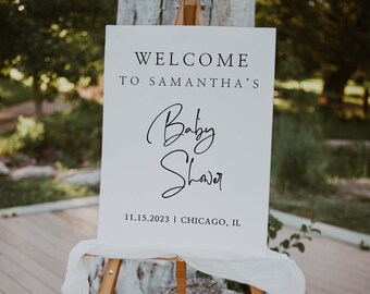 May include: White sign with black text that reads "Welcome to Samantha's Baby Shower 11.15.2023 | Chicago, IL". The sign is on a wooden easel.