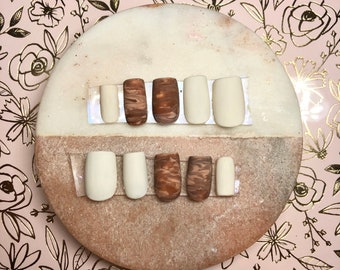 Peut inclure: Un ensemble de dix faux ongles, cinq sont de couleur brun clair avec un motif marbré et cinq sont d'un blanc uni.