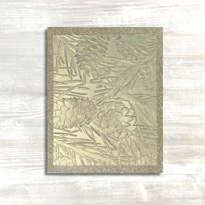 Compartilhe desejos calorosos com um cartão de felicitações perenes e pinhas em relevo dourado, finalizado com papel brilhante para um toque elegante feito à mão.