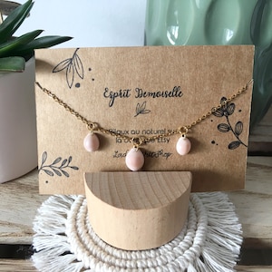 Peut inclure: Un collier en chaîne dorée avec trois pendentifs en pierre rose. Le collier est présenté sur une carte marron avec le texte "Esprit Demoiselle" et "Bijoux au naturel sur la boutique Etsy Lad's Petit Shop".
