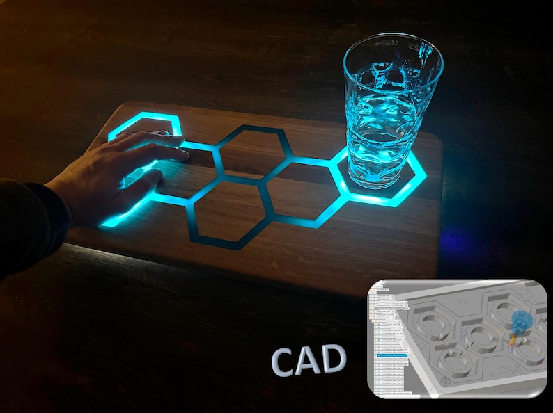 K&ouml;nnte beinhalten: Ein Holztablett mit einem Wabenmuster und blauen LED-Lichtern. Das Tablett ist beleuchtet und ein Glas Wasser steht darauf. Der Text "CAD" ist in der unteren rechten Ecke des Bildes sichtbar.