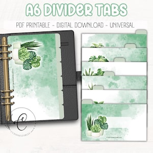 May include: A6 divider tabs with a watercolor design. The tabs feature a green watercolor wash background with botanical illustrations of plants. The text "A6 DIVIDER TABS" is at the top, with "PDF PRINTABLE - DIGITAL DOWNLOAD - UNIVERSAL" below.