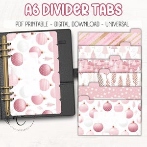 May include: Pink A6 divider tabs with various designs, including Christmas ornaments, trees, and gold stripes. The tabs are displayed in a black binder. Text on the image reads "A6 DIVIDER TABS" and "PDF PRINTABLE - DIGITAL DOWNLOAD - UNIVERSAL."