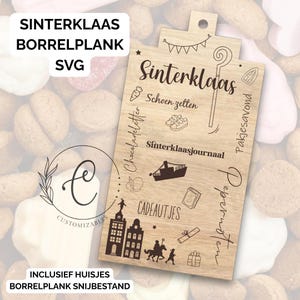Op de afbeelding: Houten snijplank met de tekst "Sinterklaas" en diverse illustraties. De plank bevat Nederlandse tekst, zoals "Schoen zetten" en "Cadeautjes". De plank heeft een gat om op te hangen en is omringd door koekjes.