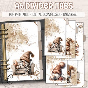 May include: A6 divider tabs with gnome illustrations. The tabs feature gnomes in cozy settings with coffee cups and hats. The design includes a neutral color palette with brown and beige tones, and the text "A6 DIVIDER TABS" is at the top.