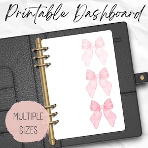 Op de afbeelding: Printbare dashboard met drie roze aquarel linten in verschillende maten. De dashboard bevindt zich in een zwarte lederen planner.