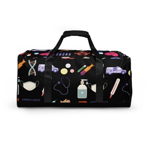 May include: Black duffel bag with a colorful pattern of medical symbols, including a stethoscope, syringe, thermometer, pills, and an ambulance. The bag has black straps and a black zipper.