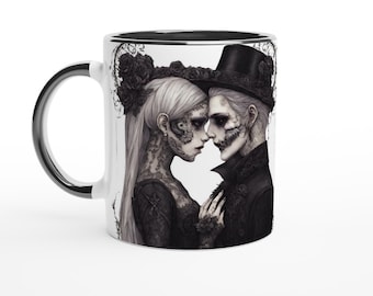 May include: A white ceramic mug with a black rim and handle. The mug features a black and white illustration of a couple in a gothic style, with the woman wearing a black lace dress and the man wearing a black suit and top hat.