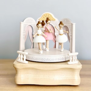 This music box plays 'Annie Laurie' while the ballerinas spin and twirl. The perfect gift for aspiring dancers or lovers of ballet!