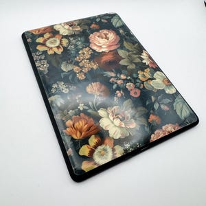 May include: A black case with a floral design. The flowers are in shades of pink, orange, yellow, and green on a dark background.
