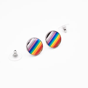 Può includere: Un paio di orecchini a bottone argentati con un design a strisce arcobaleno e grigio.