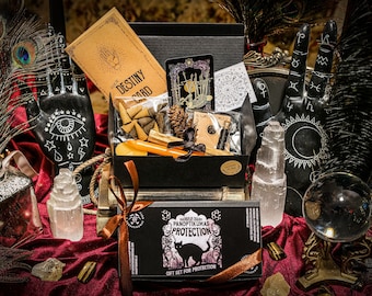 May include: A black box with gold trim containing a variety of items, including a deck of cards, incense, and crystals. The box is labelled 'Your Destiny Card' and 'World Old Panoptikumas Protection Gift Set for Protection'. The box is surrounded by black feathers, crystals, and a crystal ball.