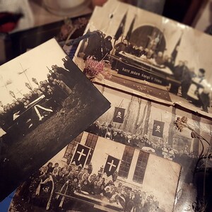 K&ouml;nnte beinhalten: Eine Sammlung von Schwarzwei&szlig;fotos, die eine Trauerprozession zeigen. Die Fotos zeigen eine Gruppe von Menschen, die sich um einen Sarg versammelt haben, einige tragen Flaggen und andere halten Kerzen. Der Text auf einem der Fotos lautet "Kolis Pedaro Dangol o Jomo".