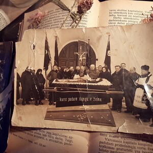 K&ouml;nnte beinhalten: Ein Schwarzwei&szlig;-Foto aus der Zeit, das eine Trauerprozession zeigt. Eine Gruppe von Menschen in dunkler Kleidung steht um einen Sarg herum. Der Text "kuris padarė dangu ir žeme" ist am unteren Rand des Bildes zu sehen.