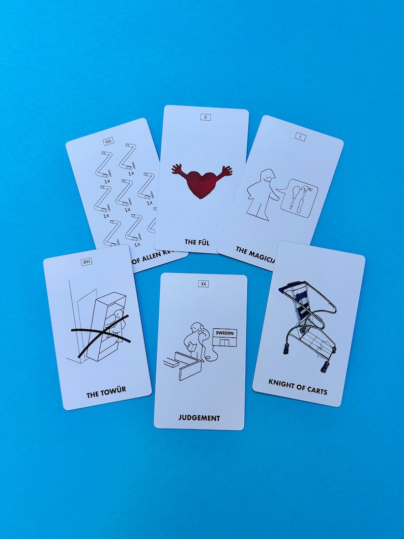 May include: Six white cards with black and red illustrations and text, including "THE F&Uuml;L", "THE MAGICIAN", "THE TOW&Uuml;R", "JUDGEMENT", and "KNIGHT OF CARTS". The cards are arranged on a blue background.