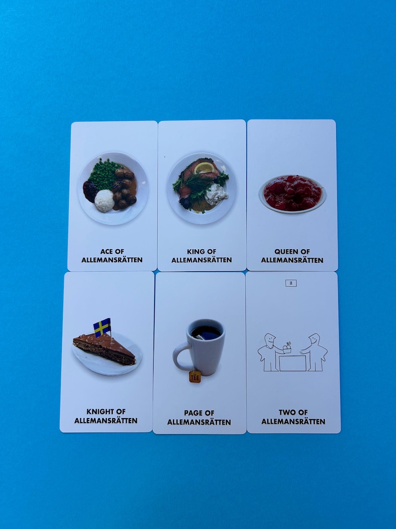 May include: Six white playing cards with food illustrations and text. The cards feature dishes like meatballs, cake with a flag, and a cup of tea. Each card has a title like "Ace of Allemansr&auml;tten."