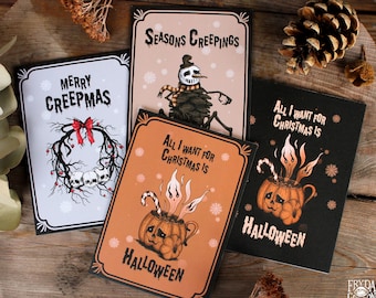 May include: Four illustrated greeting cards with a Halloween theme. The cards feature a skull wreath, a snowman, a pumpkin with a face, and a pumpkin mug with a face. The text on the cards reads "Merry Creepmas", "Seasons Creepings", "All I Want for Christmas is Halloween", and "All I Want for Christmas is Halloween".