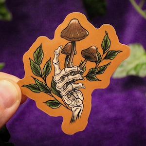 Adesivo de vinil com cogumelos na mão de esqueleto - Adesivo de cogumelo de bruxa Adesivo gótico Adesivo de laptop de cogumelo de bruxa Adesivo de esqueleto Arte de Halloween