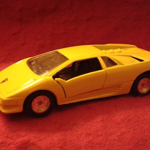 Puede incluir: Un coche de juguete amarillo modelo de un Lamborghini Diablo.