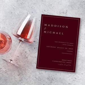 May include: A burgundy wedding invitation with white text. The invitation reads "Maddison & Michael request the pleasure of your company on their wedding day Saturday, August 26, 2024 5 o'clock Berkley Church 315 Queen Street East, Toronto reception to follow."