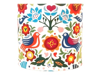 May include: A white lampshade with a colorful floral and bird pattern. The pattern features red, blue, green, yellow, and pink flowers and birds.