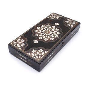 Peut inclure: Une bo&icirc;te en bois noir avec des motifs complexes en nacre incrust&eacute;s. La bo&icirc;te a un couvercle &agrave; charni&egrave;res et une bordure d&eacute;corative.